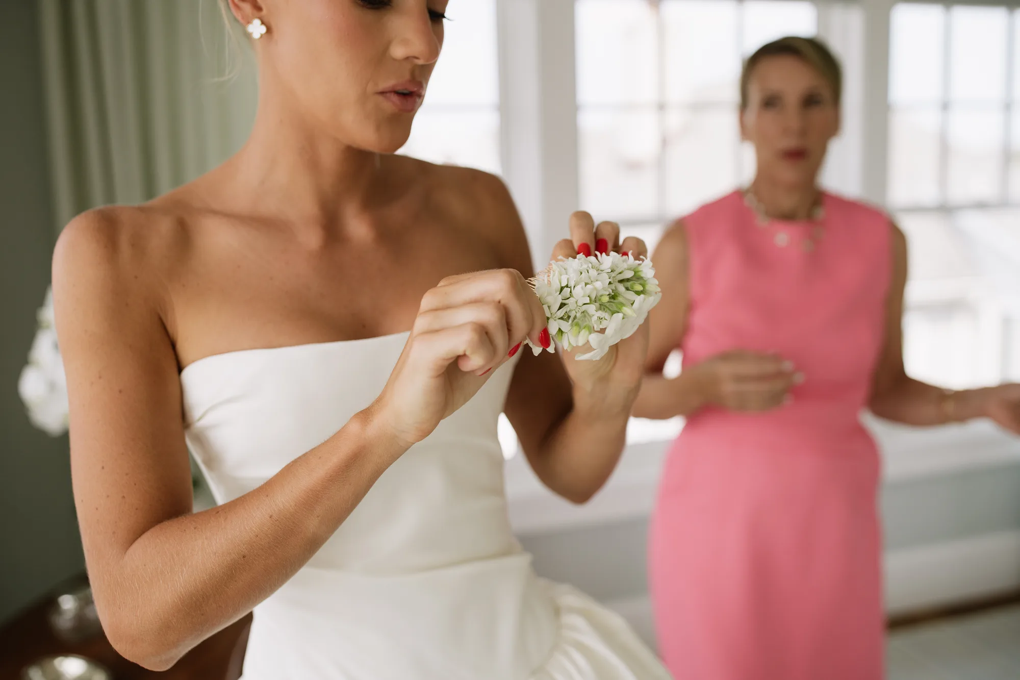 Lindsey studies a small cluster of white tweedia blooms in her hands before it is set into her hair