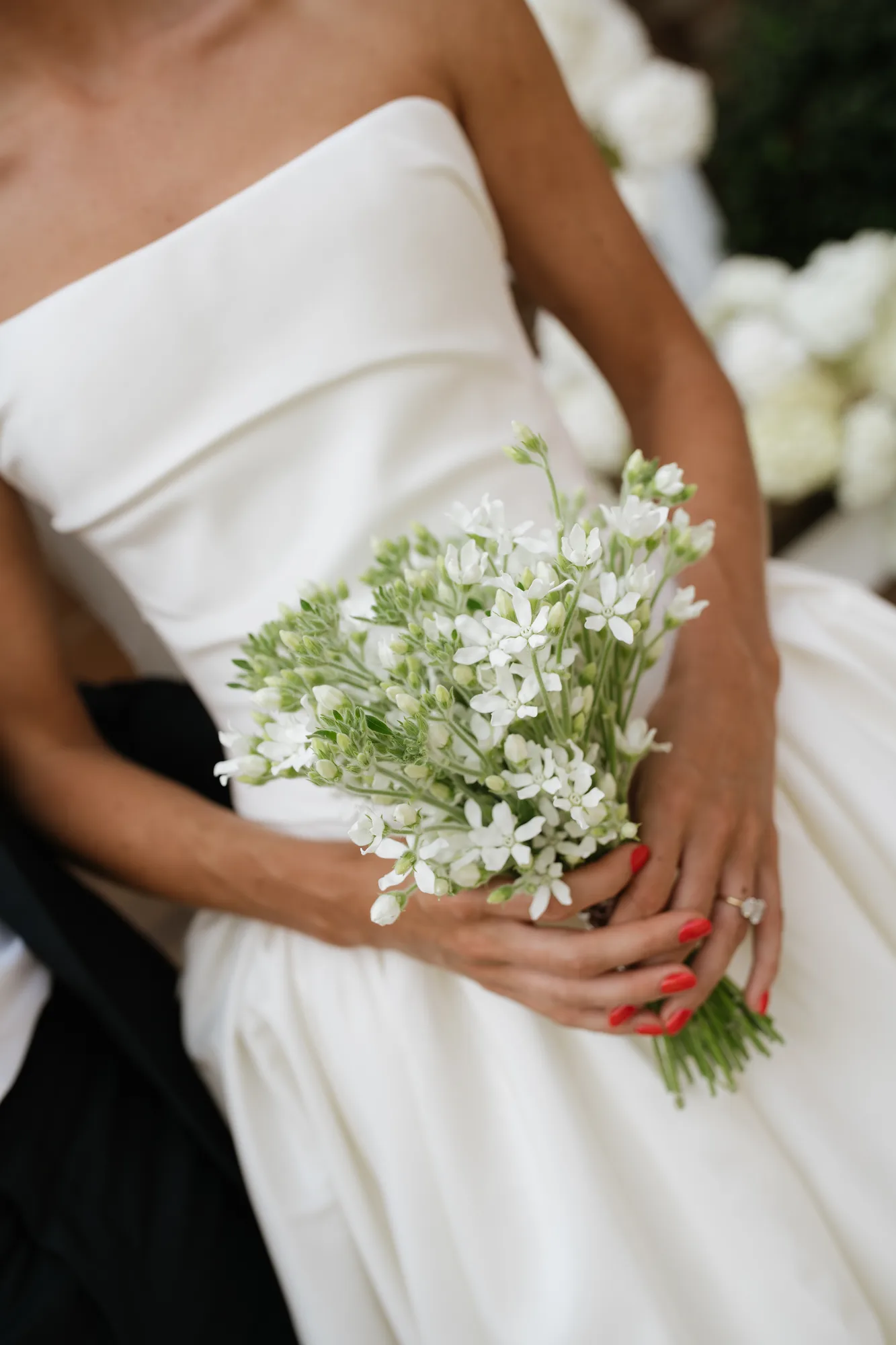 Lindsey's petite tweedia bouquet held against her gown, white star-shaped blooms over pale green buds