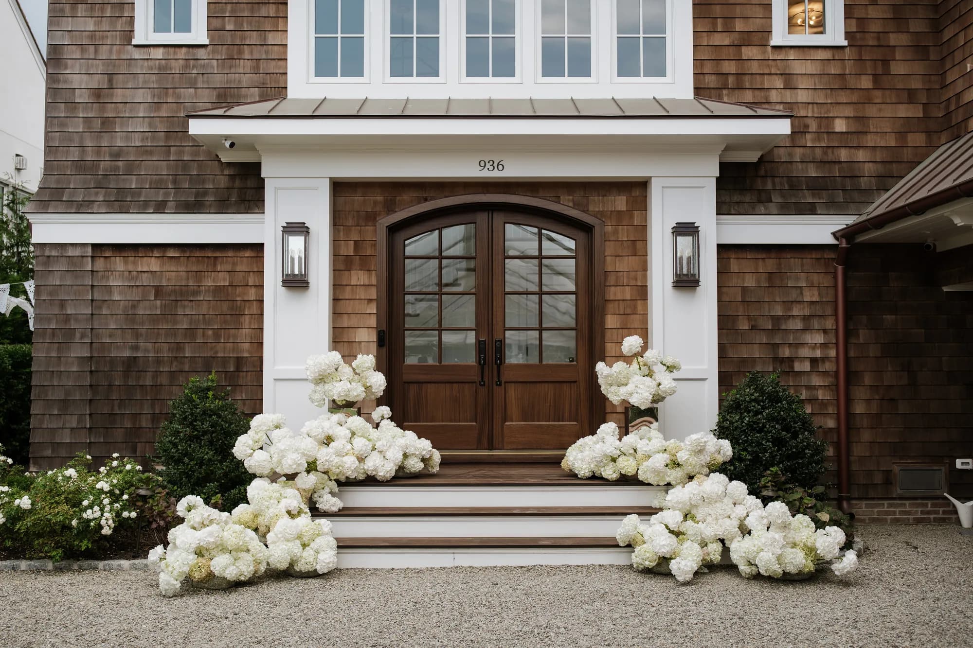The front steps before the ceremony, white hydrangea massed in drifts on either side of the arched wood doors