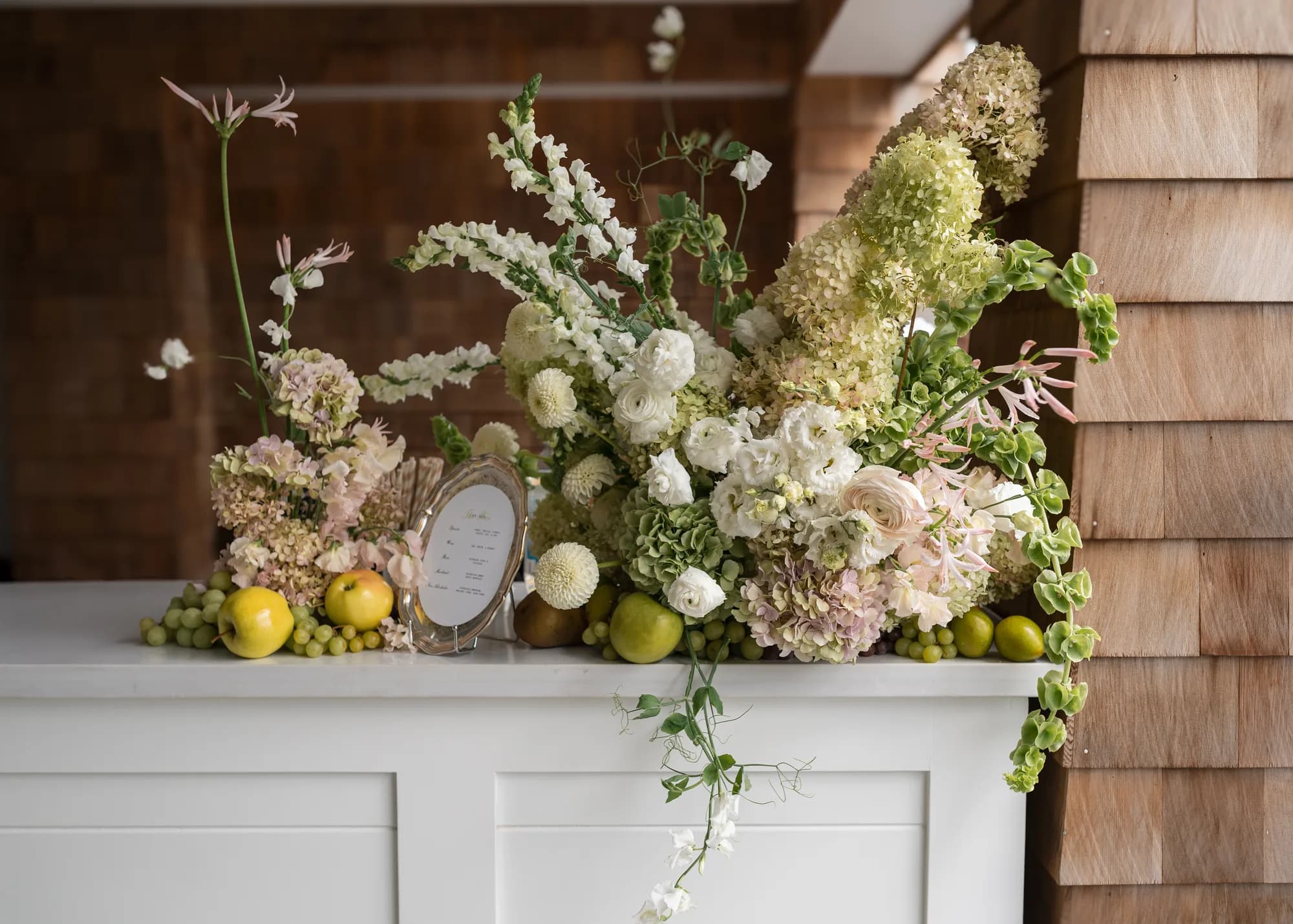 The bar arrangement head-on: limelight hydrangea, snapdragon, nerine and ranunculus with pea vine trailing over the edge