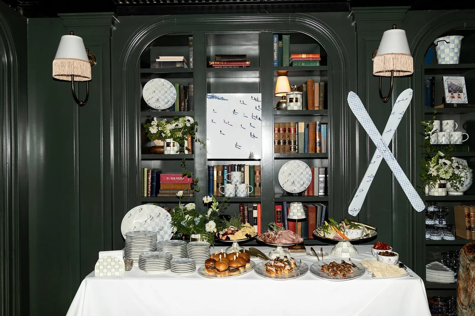 A buffet of sliders and crudites with stacked ski-print plates and a loose white arrangement under crossed skis